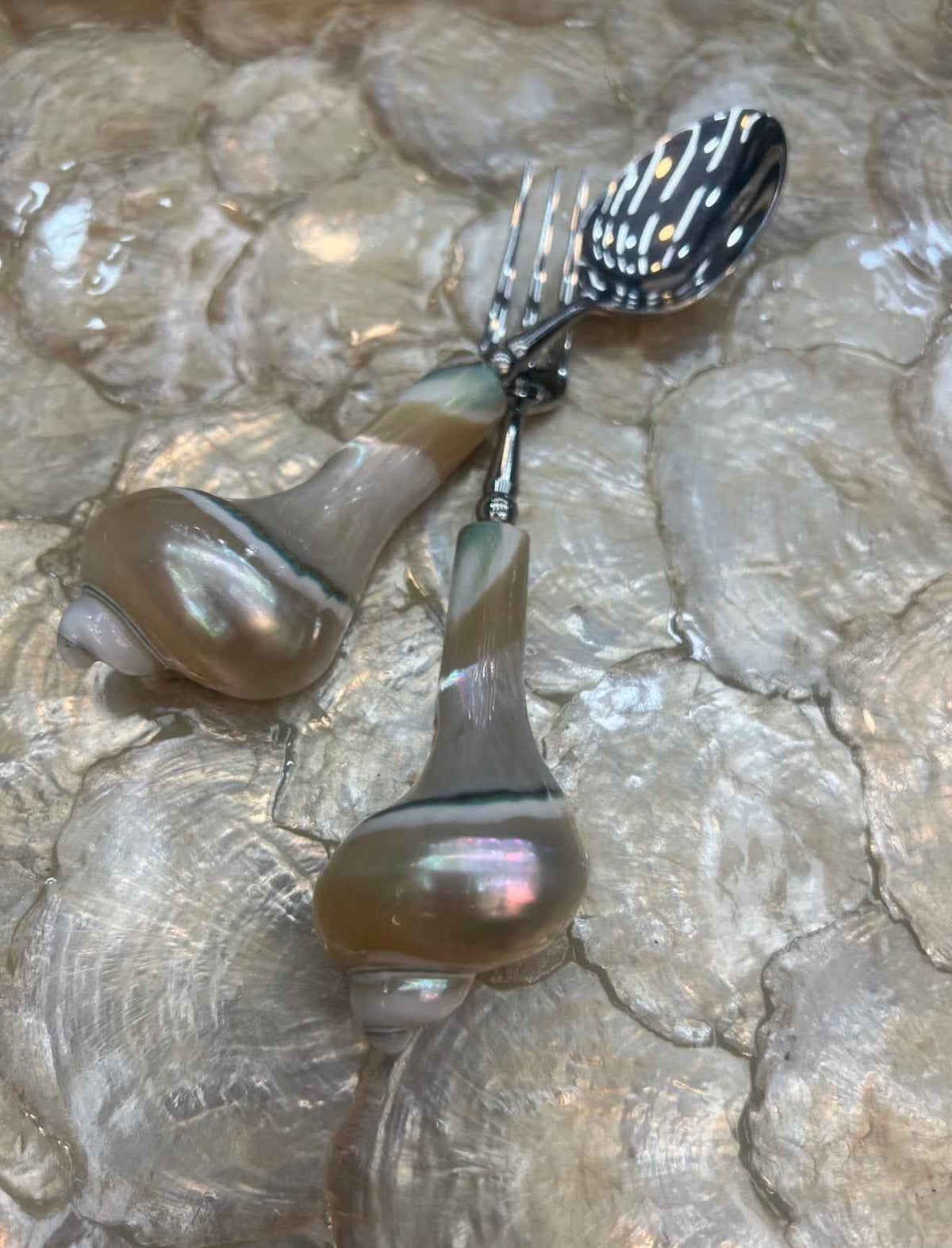 Metal spoon and fruit fork with spiral shell handle details