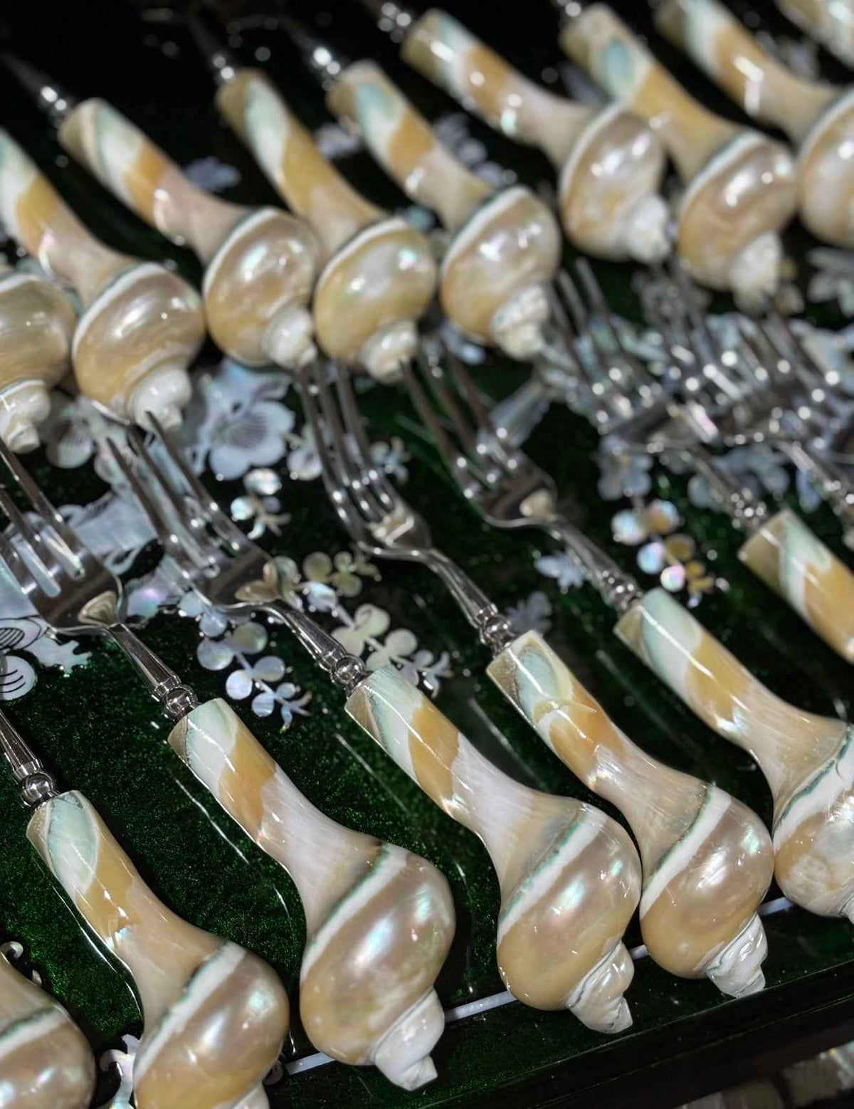 Collection of spoons and forks with natural shell handles