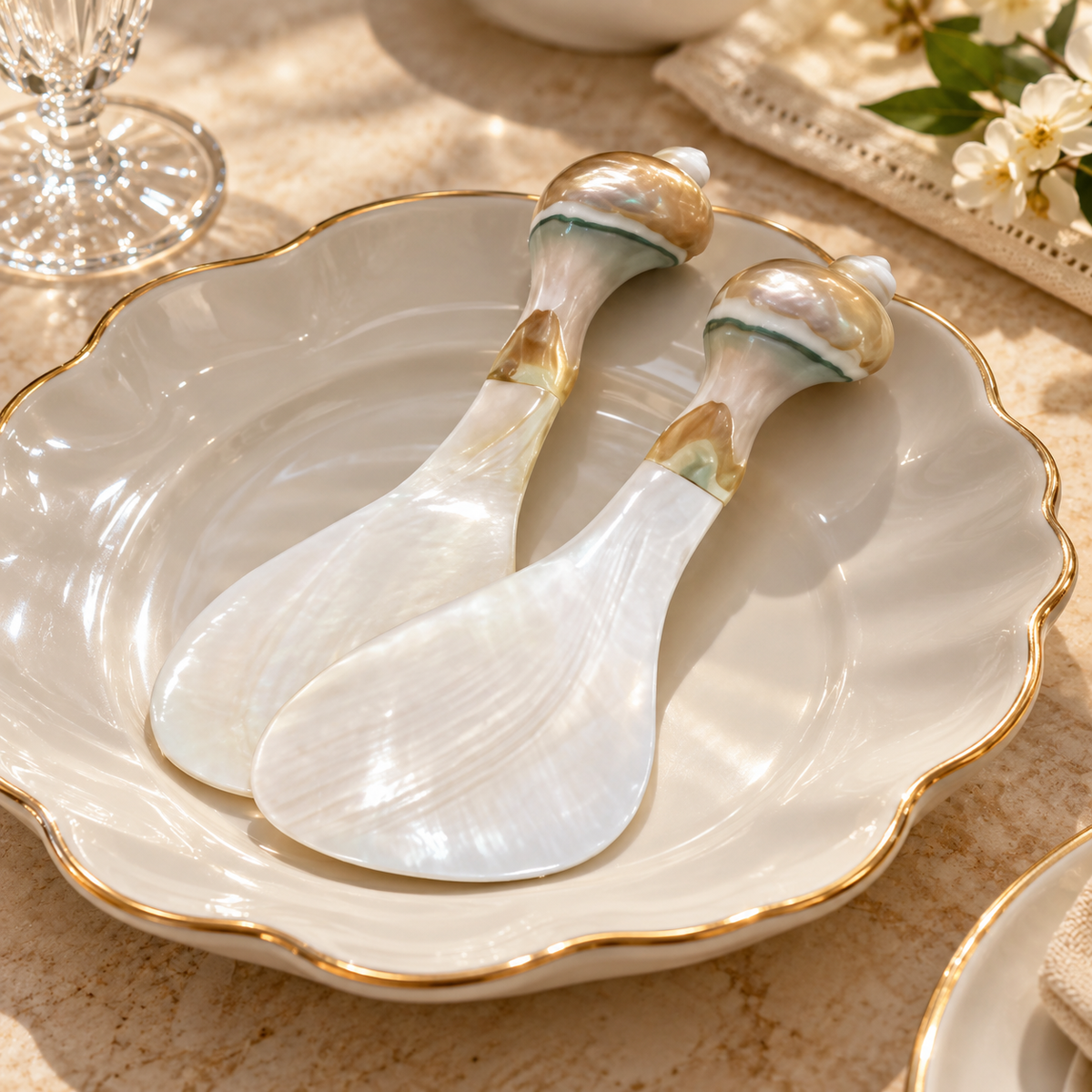 Two shell rice paddles on an ivory plate with gold rim