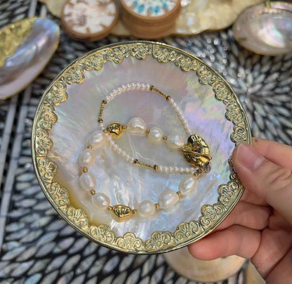 Yellow lip shell dish used as a coastal ring holder and jewelry tray on vanity